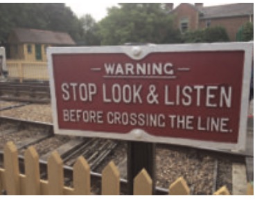 Vintage red railway warning sign reading: Stop Look & Listen Before Crossing the Line